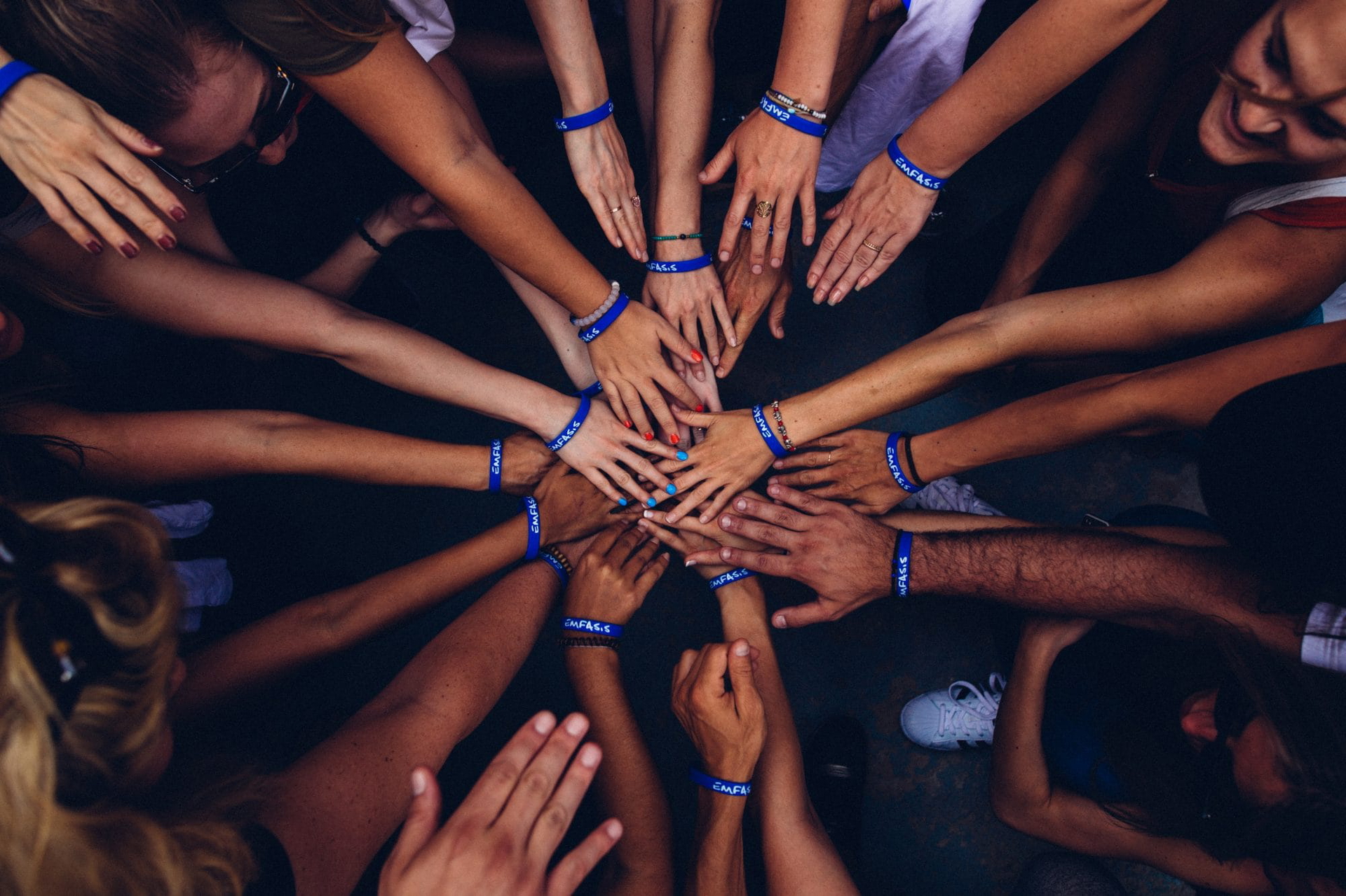 Lots of people with hands in a circle